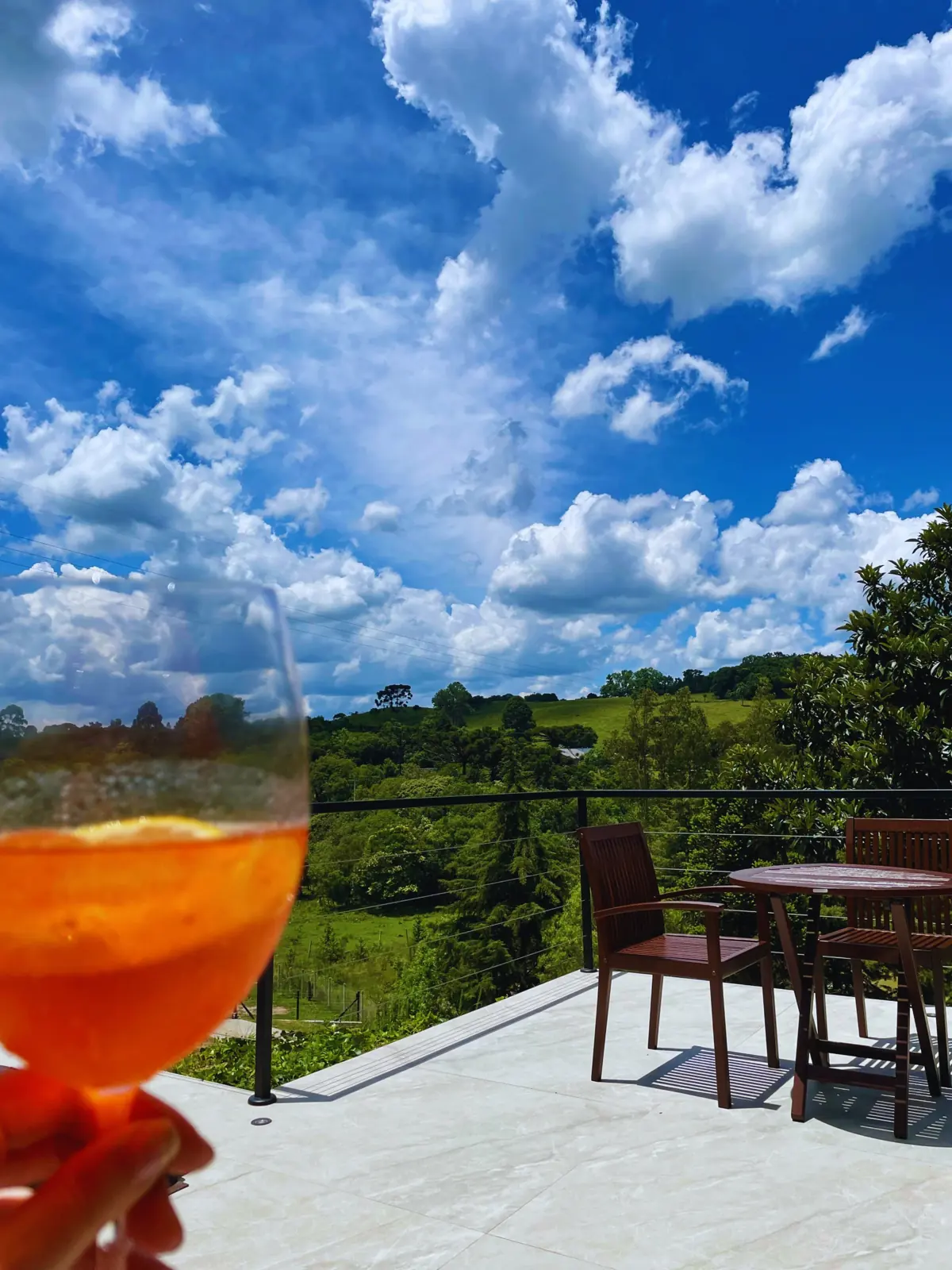 Drink no deck com vista para o vale verde e céu azul