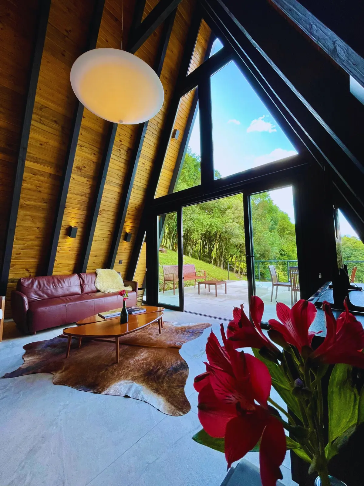 Sala integrada com portas de vidro abertas para o deck e o jardim