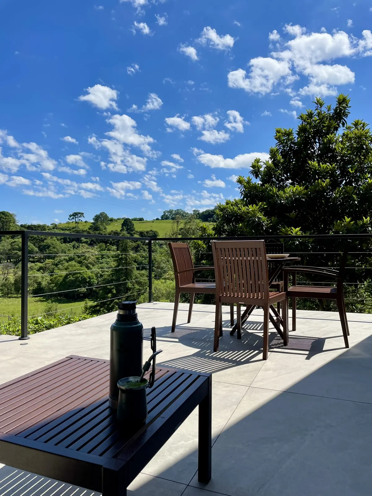 Chimarrão no deck com vista para o vale, araucárias e campos da Serra Gaúcha